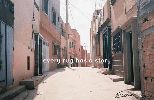 Older buildings lining street with words “every rug has a story”