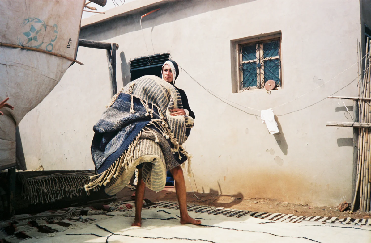 Ali Esmaili carrying an antique rug