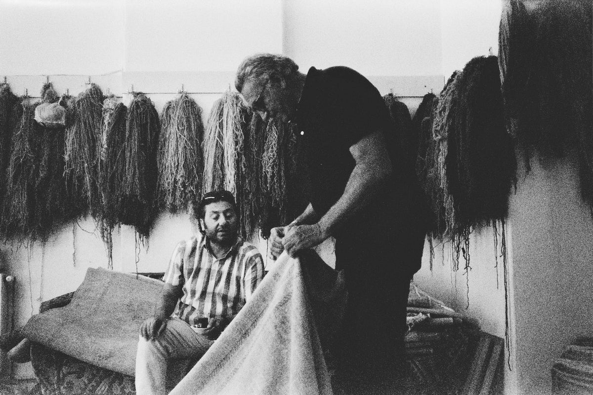 Mr. Esmaili examining an antique rug